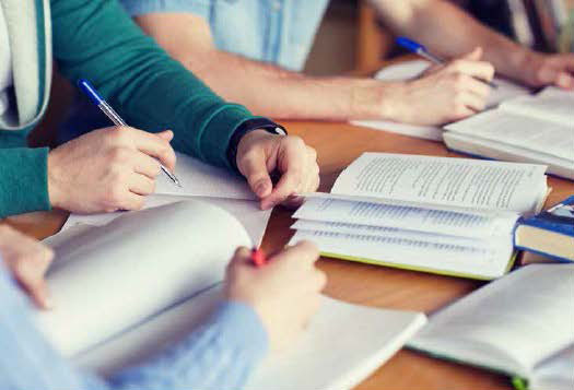 Group of people with books open studying at table